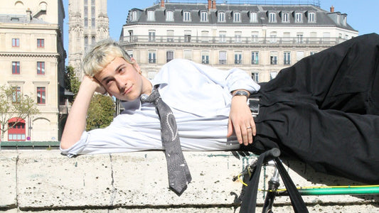 Un homme allongé sur les quais de seine avec une cravate en soie