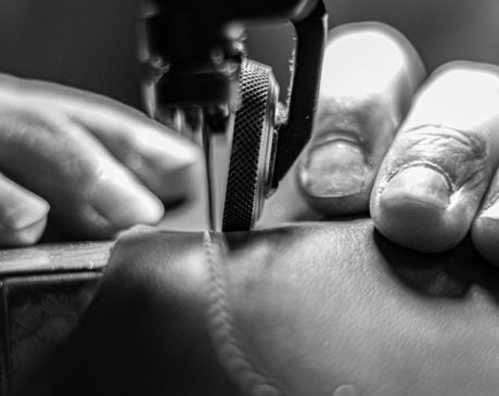 Photo d'un atelier de maroquinerie avec des mains en action 