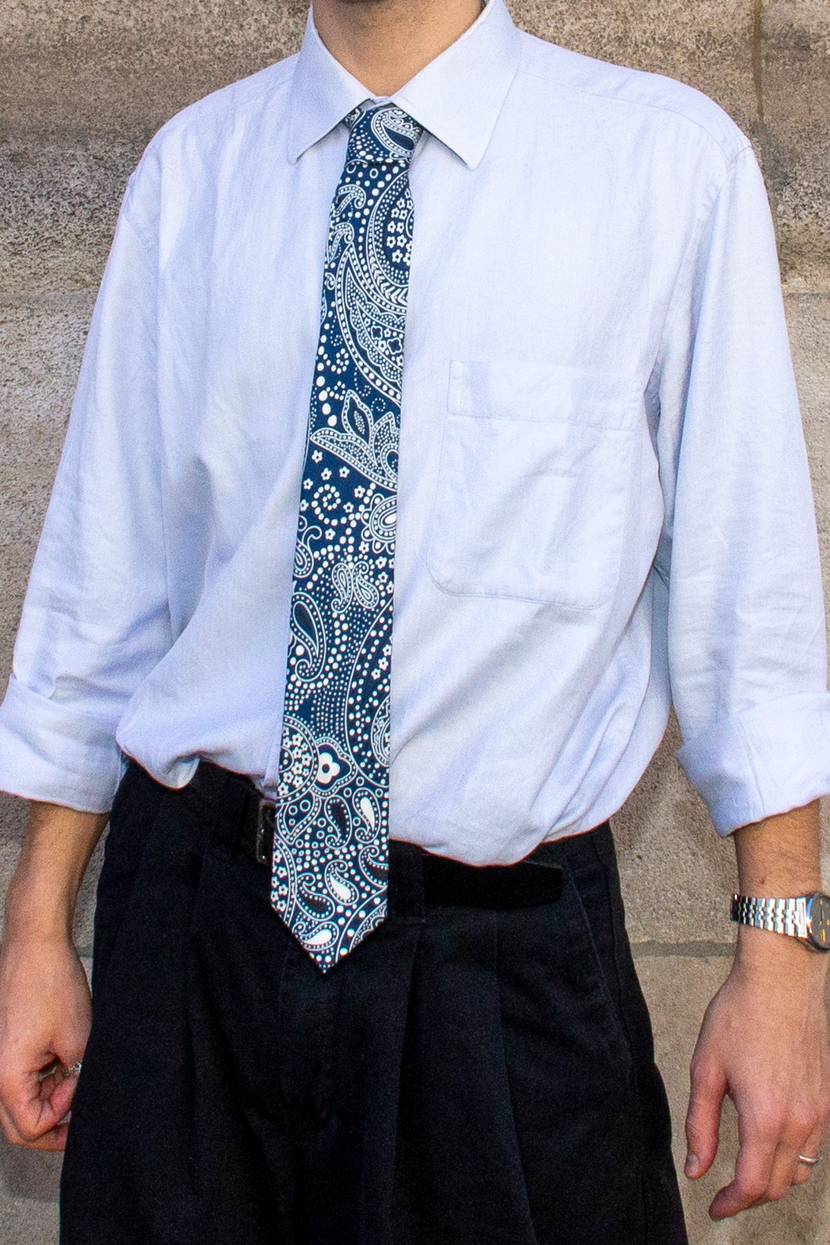 Détail de la cravate académie paysley bleu portée sur une chemise bleu ciel 
