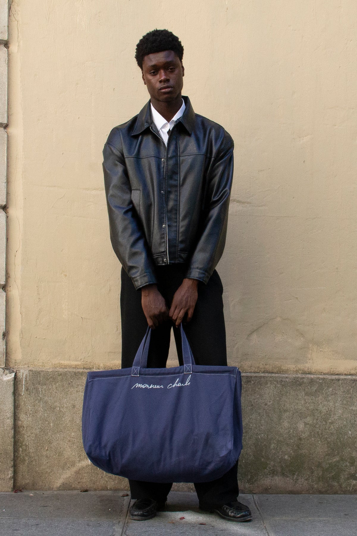 Homme en veste de cuir noir portant le maxi cabas bleu WALTER en canvas de coton à la main