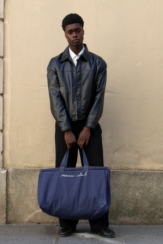 Homme en veste de cuir noir portant le maxi cabas bleu WALTER en canvas de coton à la main