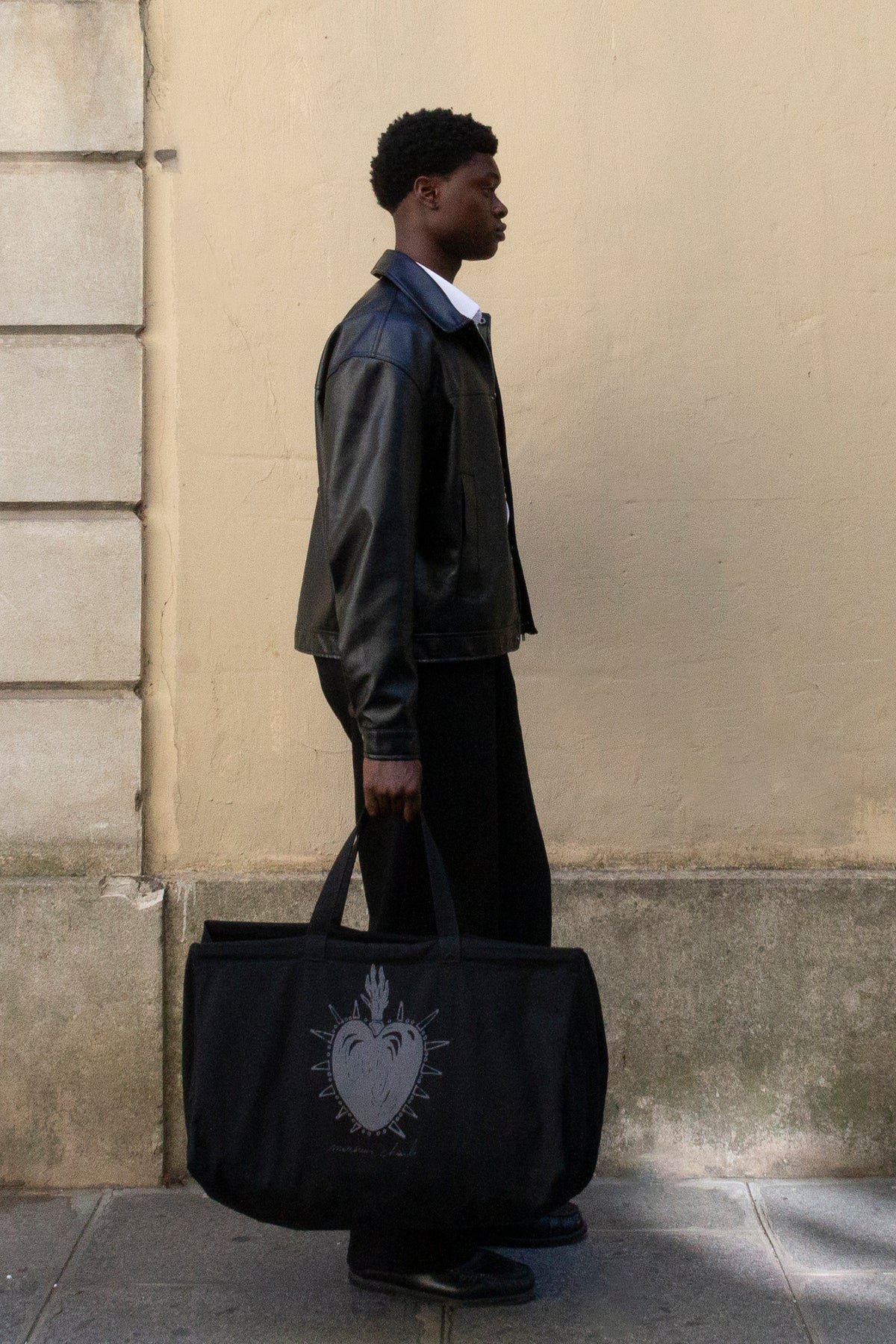 Le maxi cabas noir Walter porté à la main par un homme