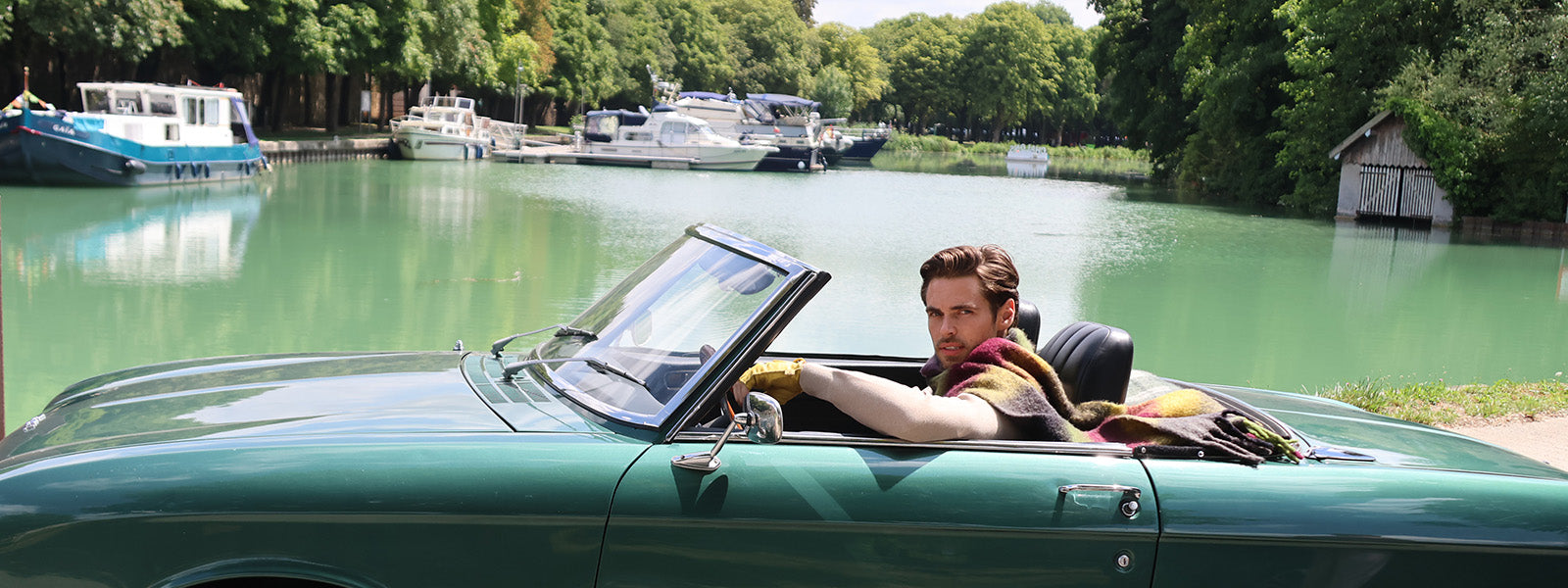 un homme dans une voiture cabriolet avec une écharpe monsieur charli 